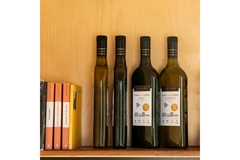 wine bottles on wooden shelf next to books, Taylor’s One Small Step Shiraz and Chardonnay packaging display